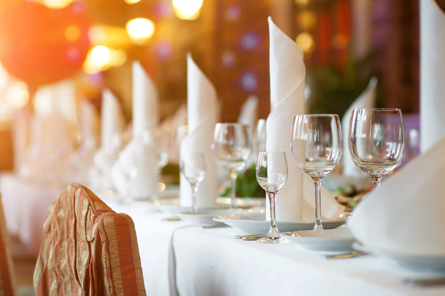 Warm candlelight and polished glasses at an elegantly set dinner table