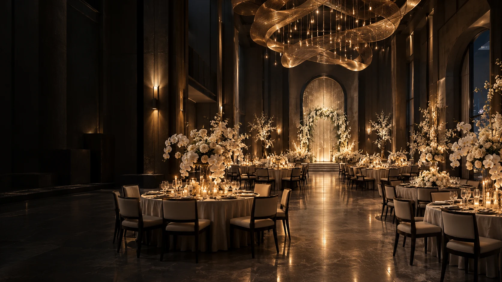 A dramatic modern ballroom with sculptural gold lighting and candlelit reception tables
