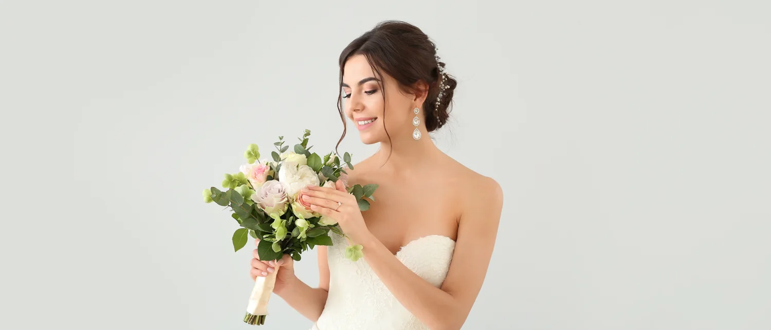 A bride holding an ivory and green floral bouquet